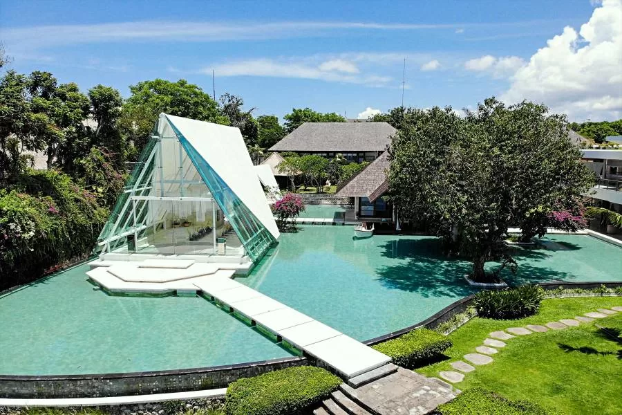 Tirtha Uluwatu's iconic glass wedding chapel stand beautifully surrounded by water, for your stunning destination wedding in Bali