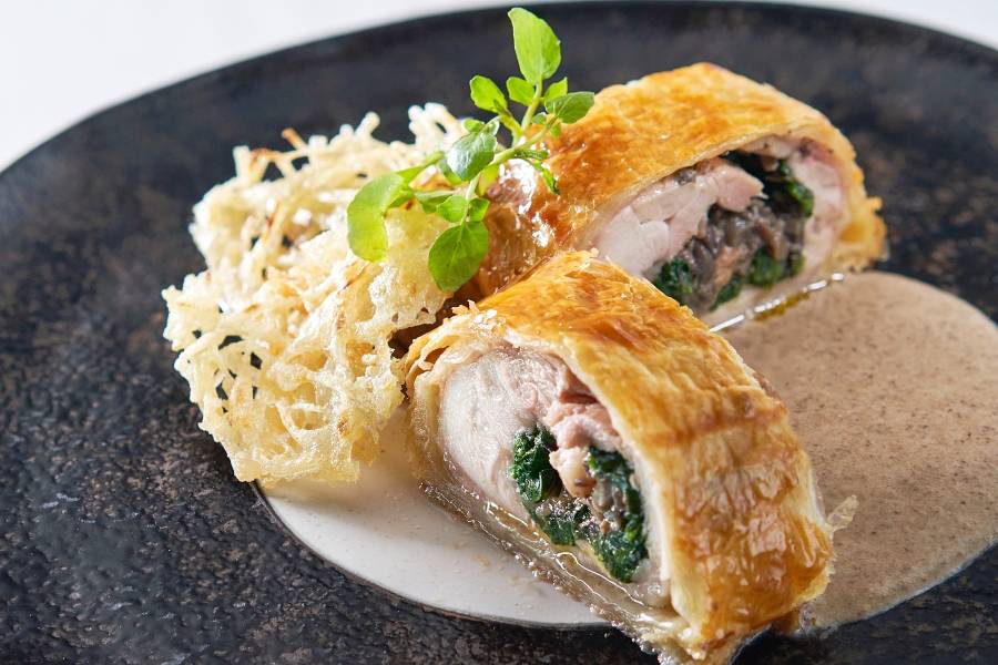 French course, main course. Baked chicken leg wrapped puff pasty in mushroom sauce