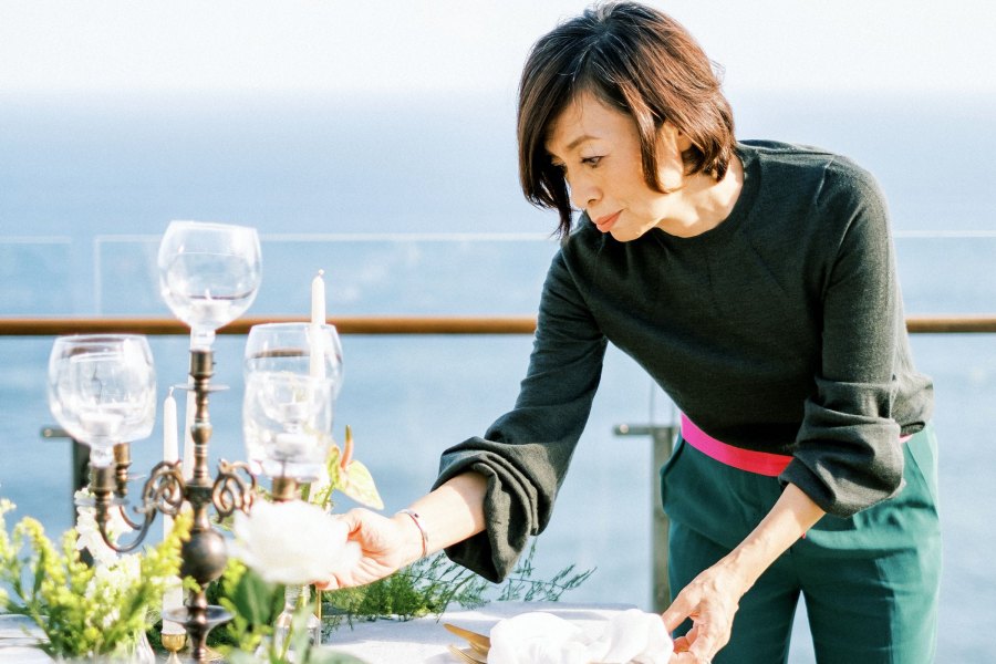 Yuka Koreyasu is working on decorating the table setup for the wedding reception