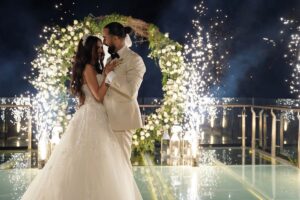 First dance on the glass stage during a cliffside wedding at Tirtha Uluwatu.