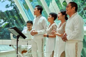 Wedding chorus singing inside the glass chapel at Tirtha Uluwatu in Bali.