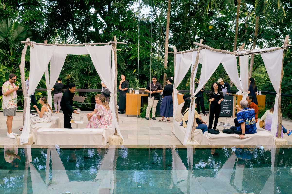 Guests enjoying a relaxed poolside gathering at the Glass House by Tirtha, Bali wedding venue.