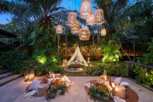 A cozy outdoor lounge setup with lights and low seating at The Glass House.