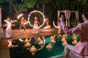 Traditional fire dance performance at a poolside reception venue by Tirtha.