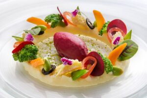 A vibrant plate of French cuisine featuring local Bali ingredients, artistically plated with seasonal vegetables.