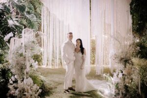 Bride and groom posing under dreamy night lighting at Tirtha Bali's Pool Terrace & Garden venue.