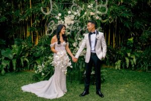 Bride and groom at a floral photo corner in a garden wedding by Tirtha Bali.