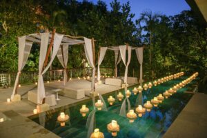 Romantic poolside reception venue with floating candles at the Glass House by Tirtha.