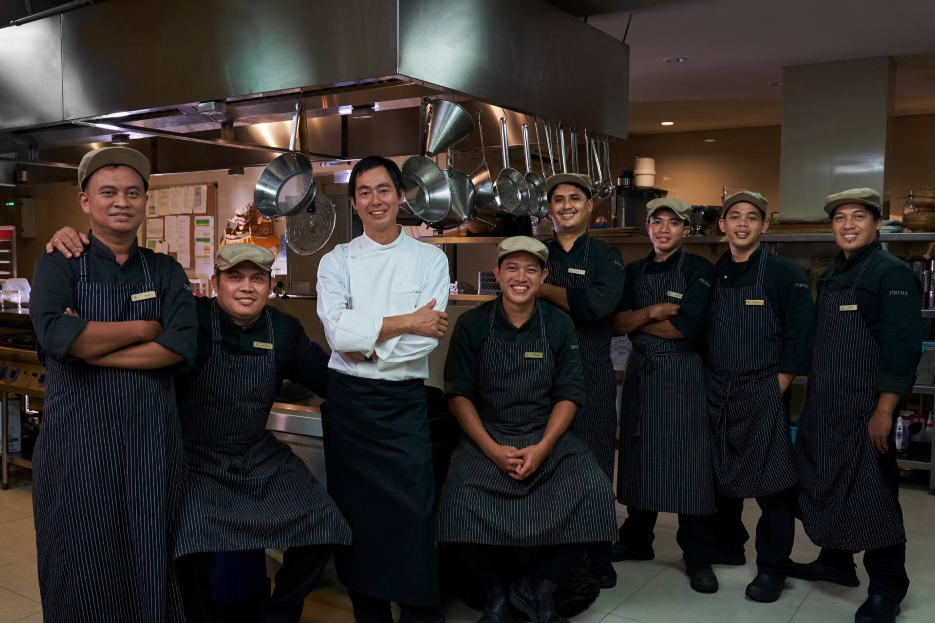 Chef Ryoichi Kano with the Tirtha Dining kitchen team, showcasing a collaborative spirit and culinary excellence in Bali.