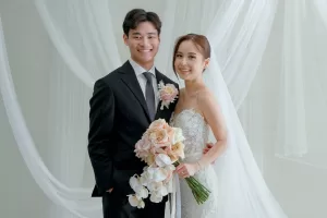 Wan Ting and Keefe smiling with blush rose bouquet at their Bali destination wedding.