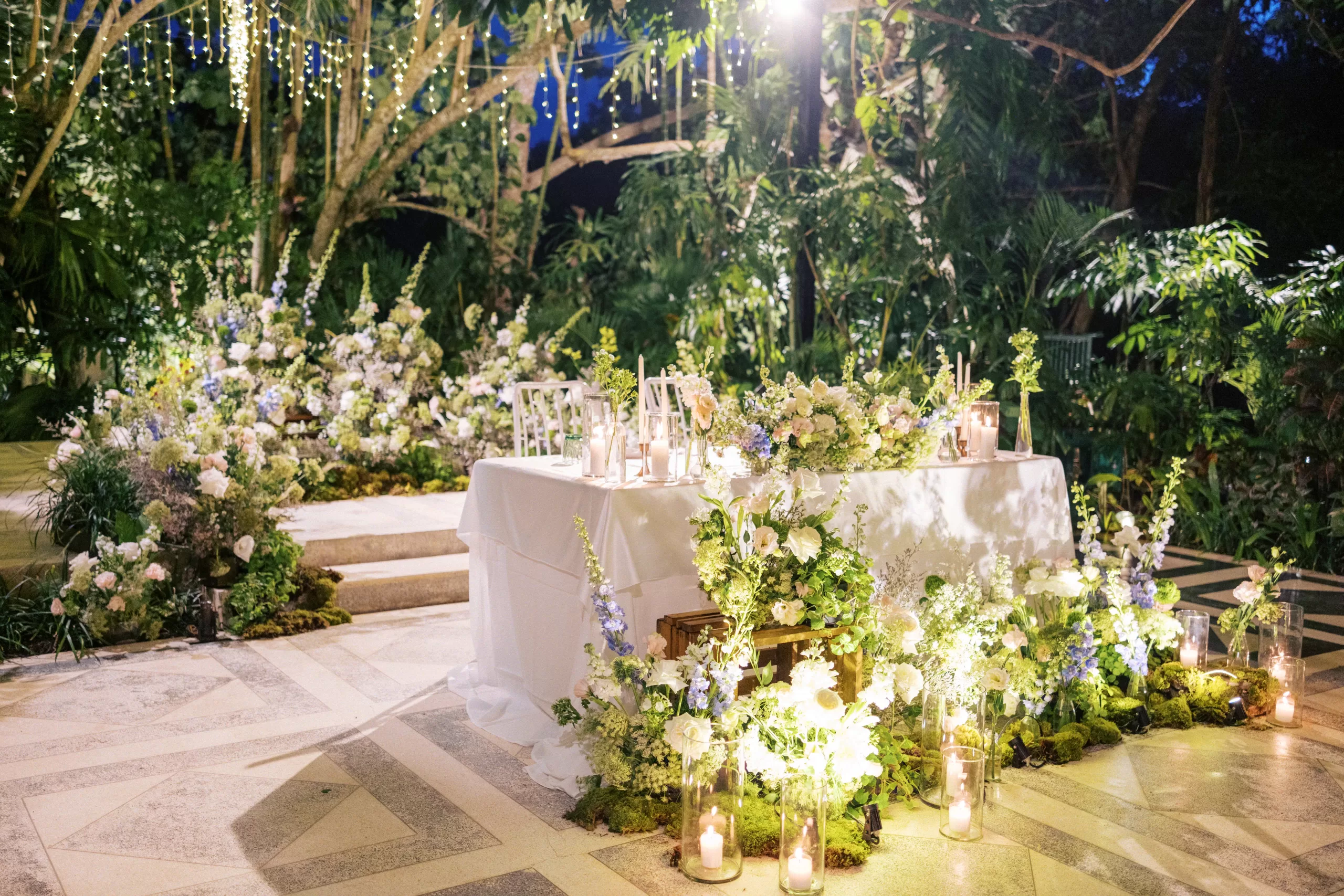 Tropical wedding decor inspiration with candlelit sweetheart table at the Moonlight Garden.