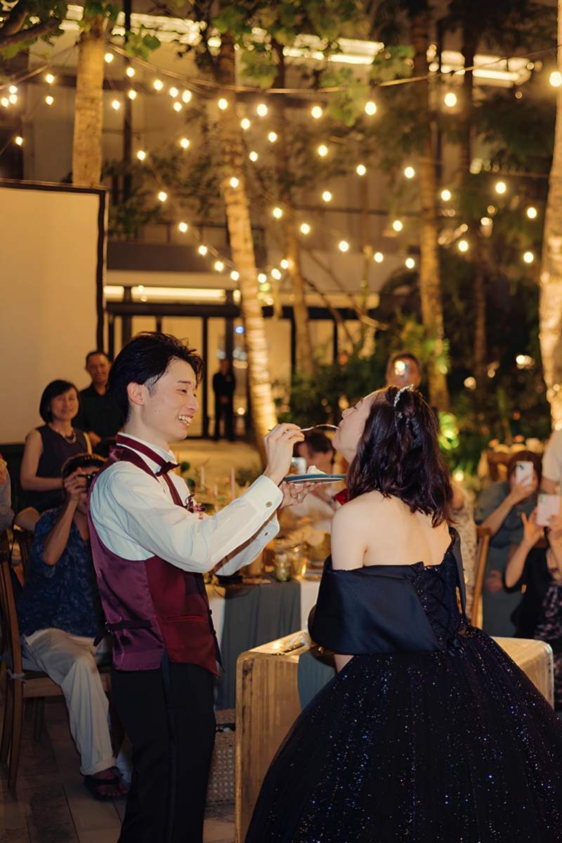 Groom feeding bride during cake ceremony at their intimate garden wedding reception at Tirtha Bali.