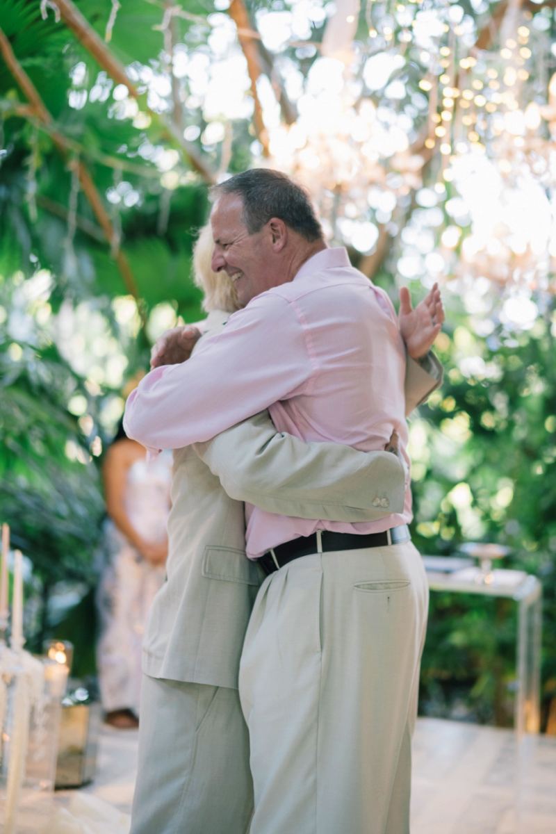 The groom shares an emotional hug with his father during the Bali destination wedding at Tirtha.