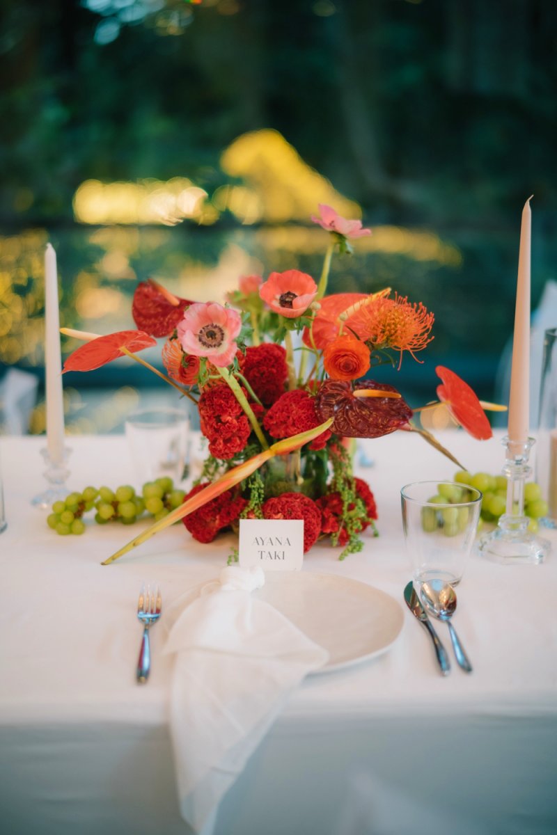 Reception florals with bold red accents from a real wedding at Tirtha Bali.