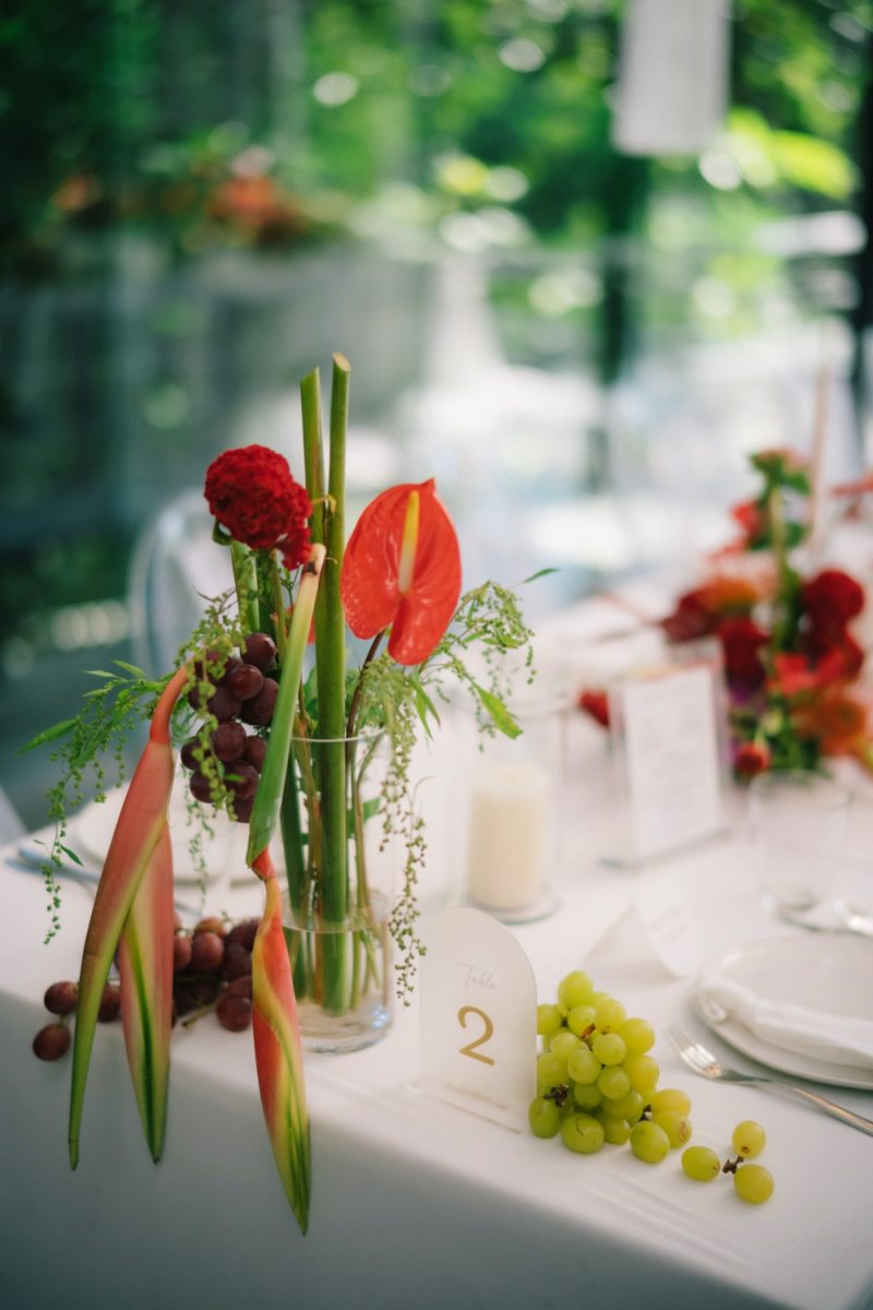 Reception table details with sculptural florals and fruit at a real wedding by Tirtha Bali.