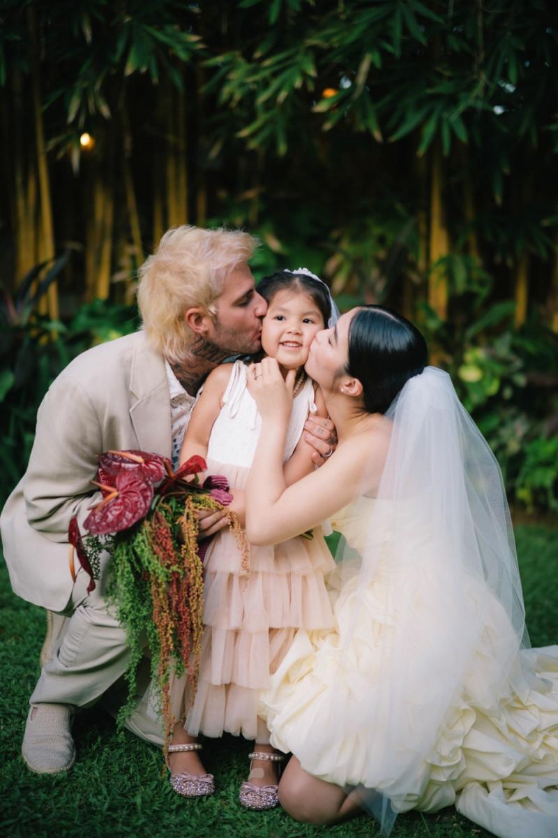 Akari & Michaljon share a sweet moment with their flower girl at Tirtha Bali, a beloved Bali wedding venue.