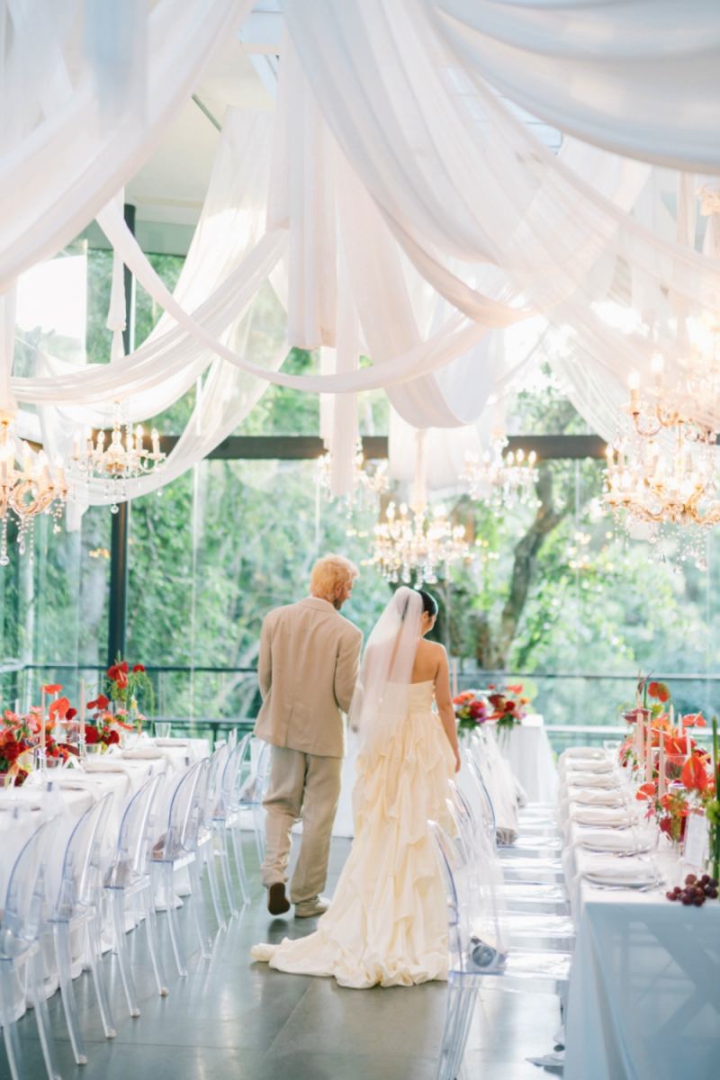 The couple walk hand in hand through their reception setup at the Plumeria Room by Tirtha Bali.