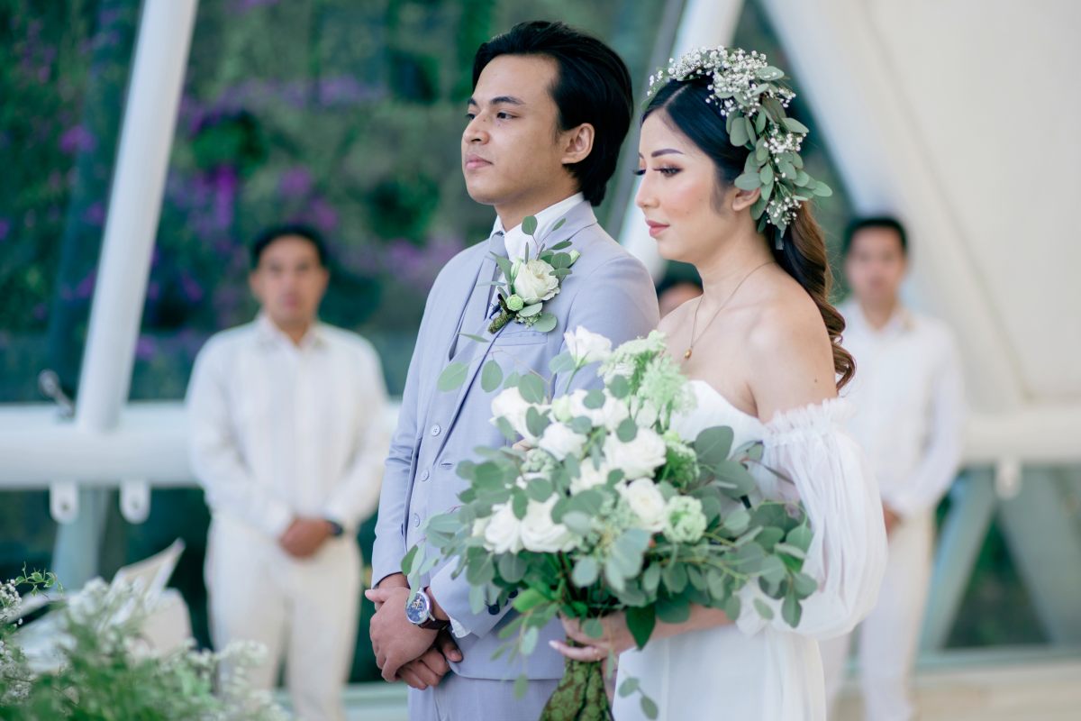 The couple stands in harmony with their wedding setting, styled as a natural extension of the surroundings.