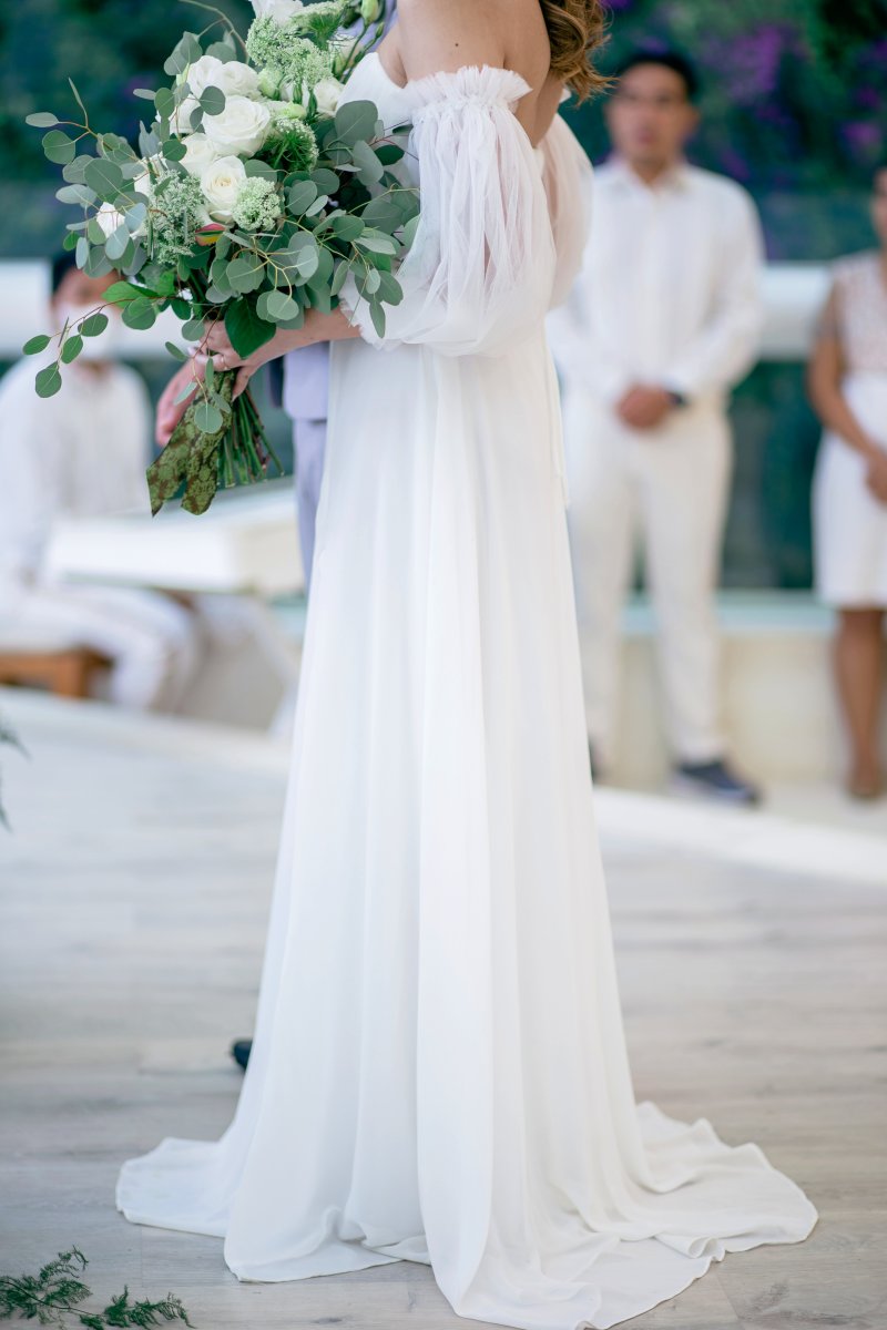 The bride’s chiffon gown flows softly, mirroring the glass chapel’s ethereal lightness.