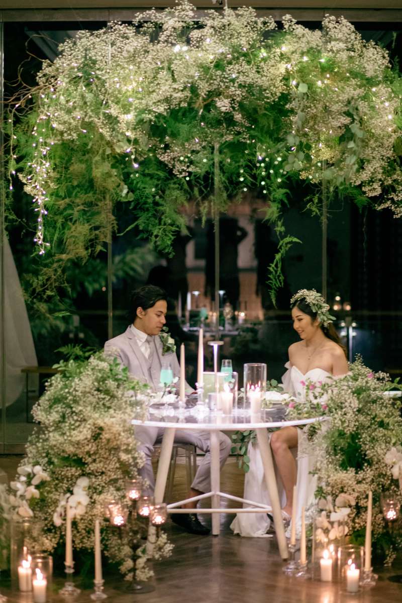 Romantic sweetheart table in the Heaven Room, surrounded by cascading greenery and candlelight.