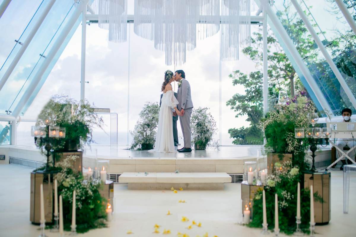 A couple shares a kiss at their wedding inside the glass chapel at Tirtha Uluwatu.