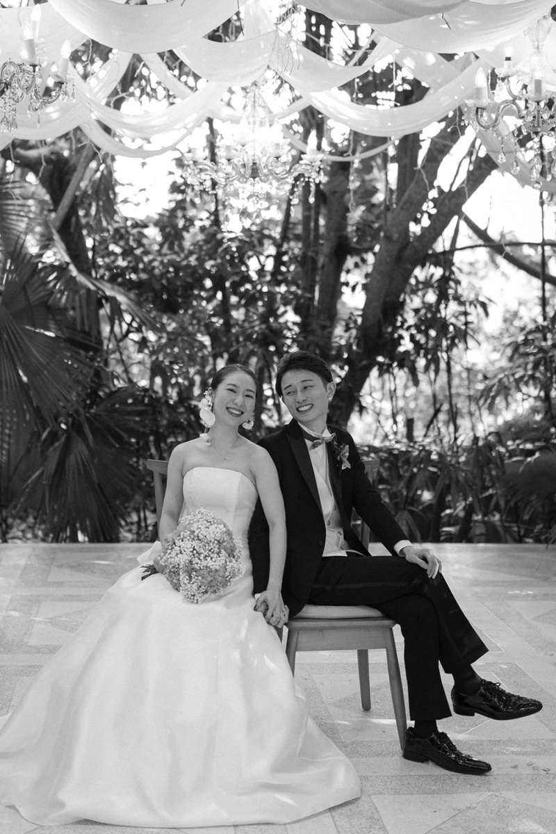 A serene moment as bride and groom sit beneath chandeliers after their Bali wedding ceremony.
