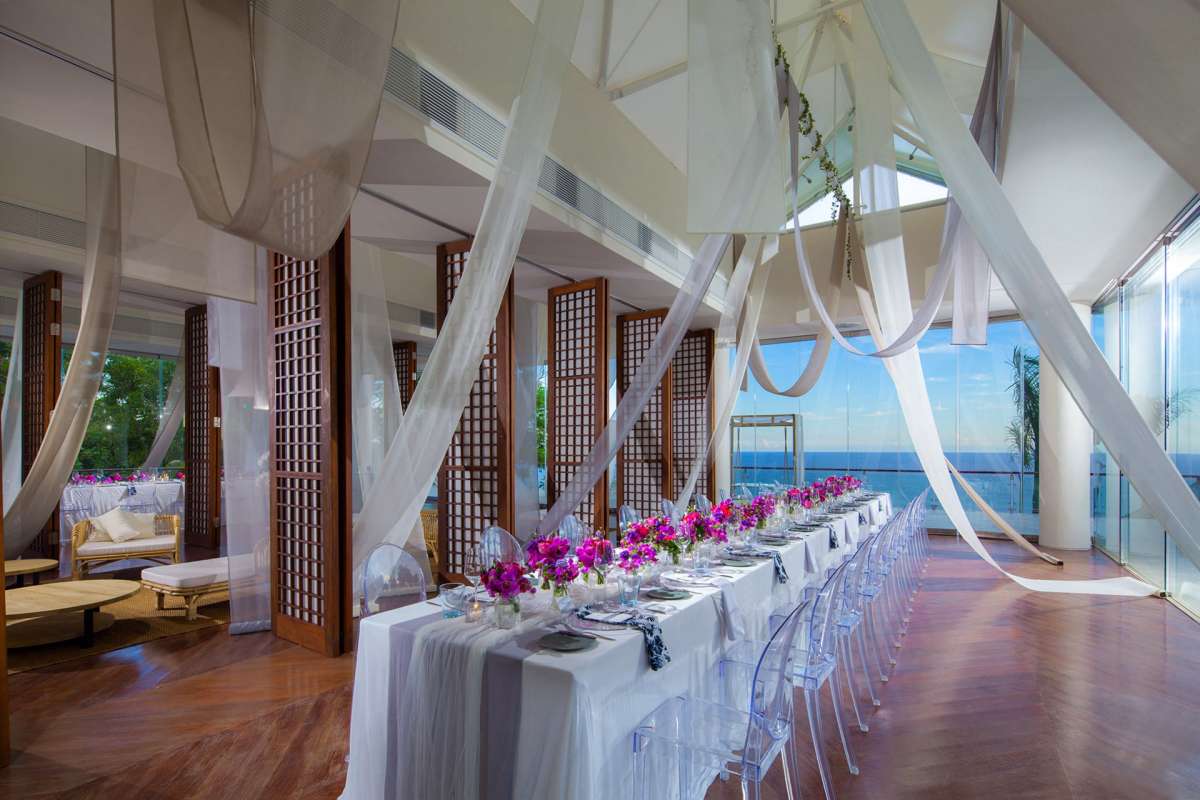Elegant reception table in the Heaven Room at Tirtha Uluwatu, with ocean views and flowing drapery.