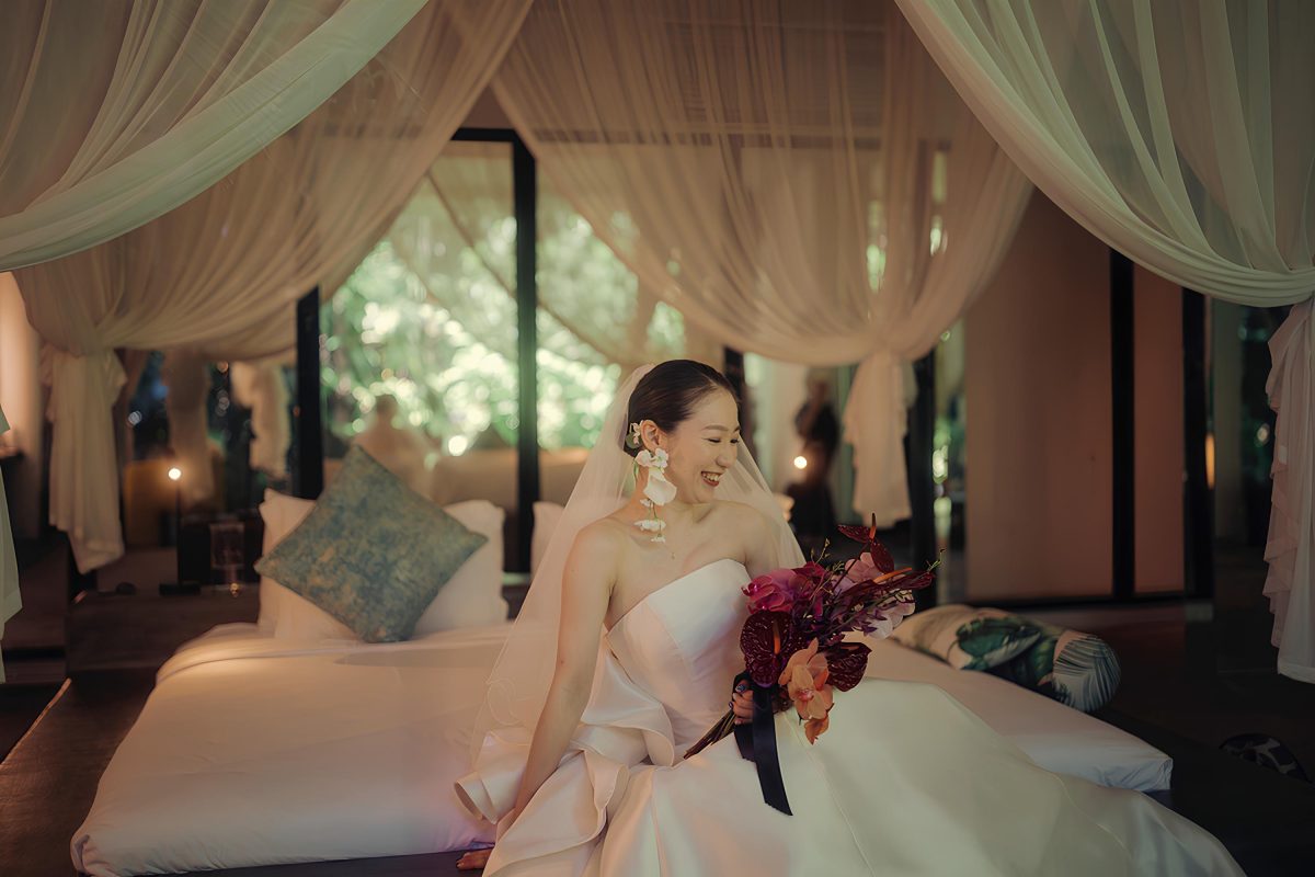 Bride Mina holding bouquet in master bedroom at Tirtha Bali wedding venue.