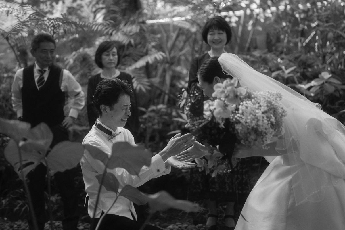 Surrounded by family, the groom proposes again to the bride at their Bali wedding venue.