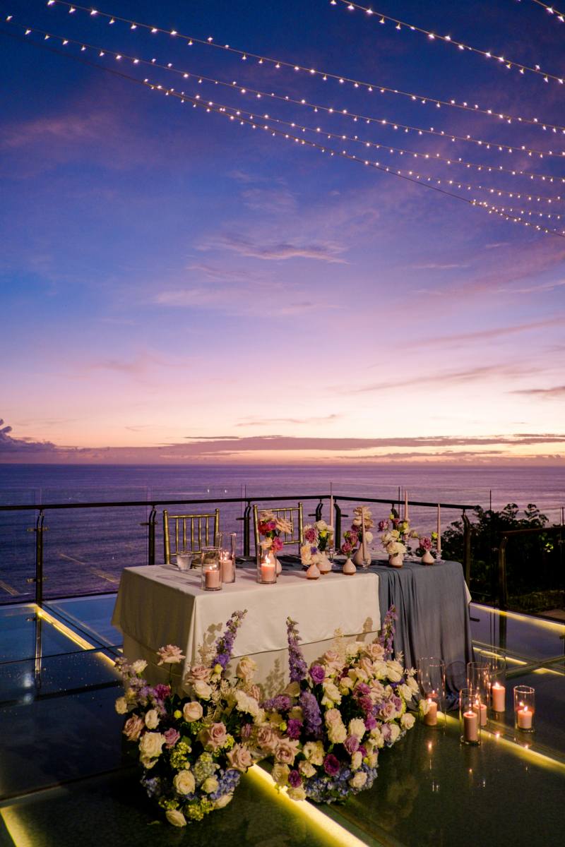 Sunset reception setup on the Glass Stage at Tirtha Uluwatu, a stunning Bali wedding venue.