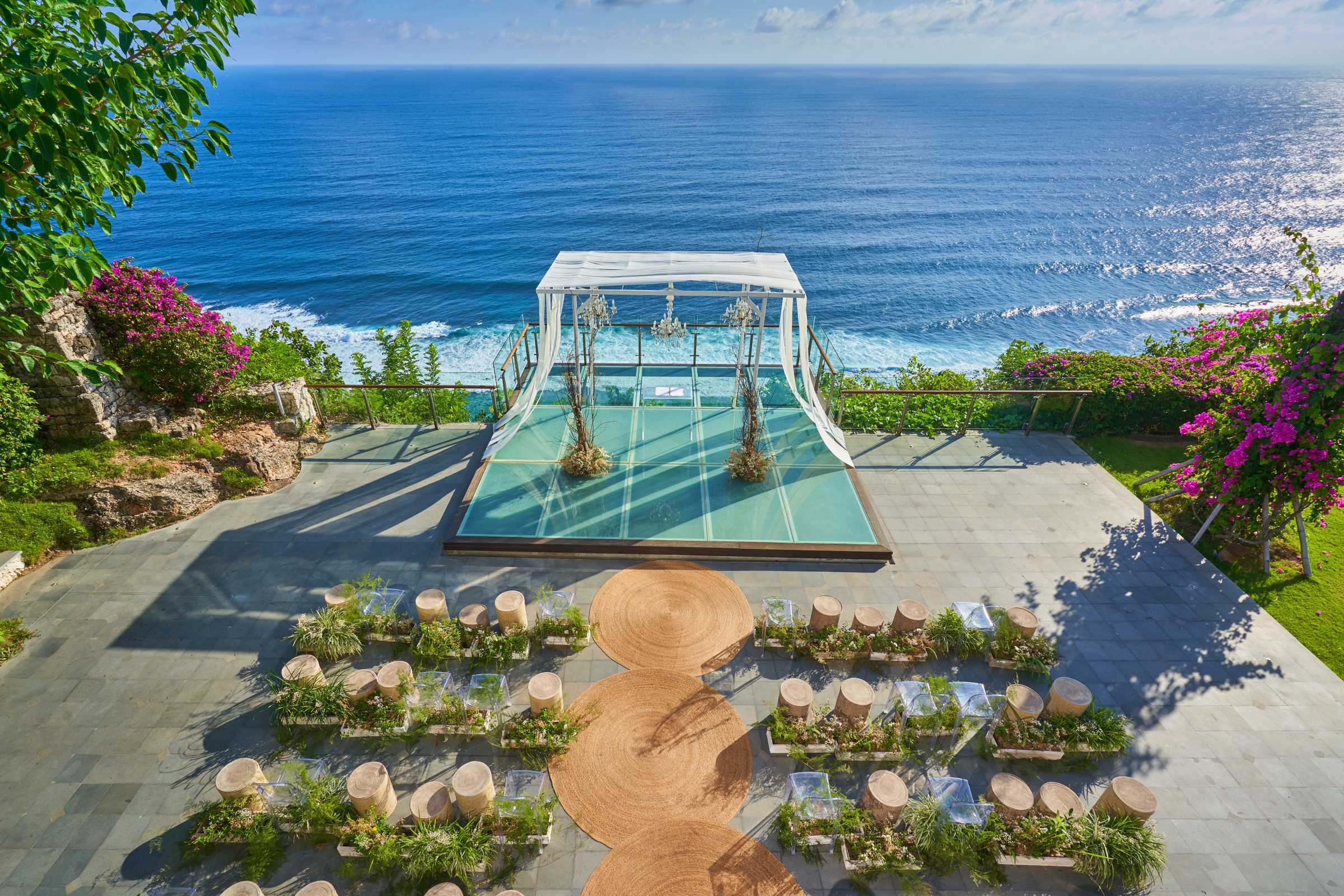 Cliffside wedding setup at Tirtha Uluwatu's glass stage with ocean views.