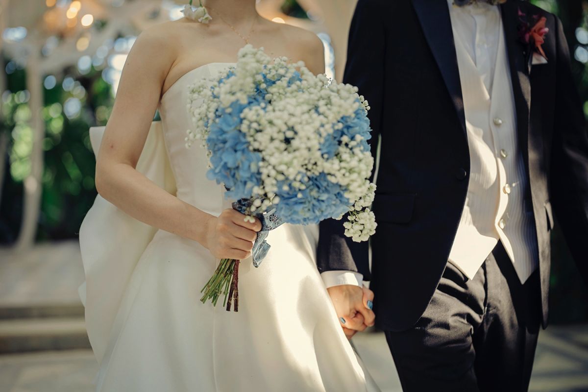 Close-up of the bride holding a blue and white bouquet during her Bali wedding ceremony at Tirtha.