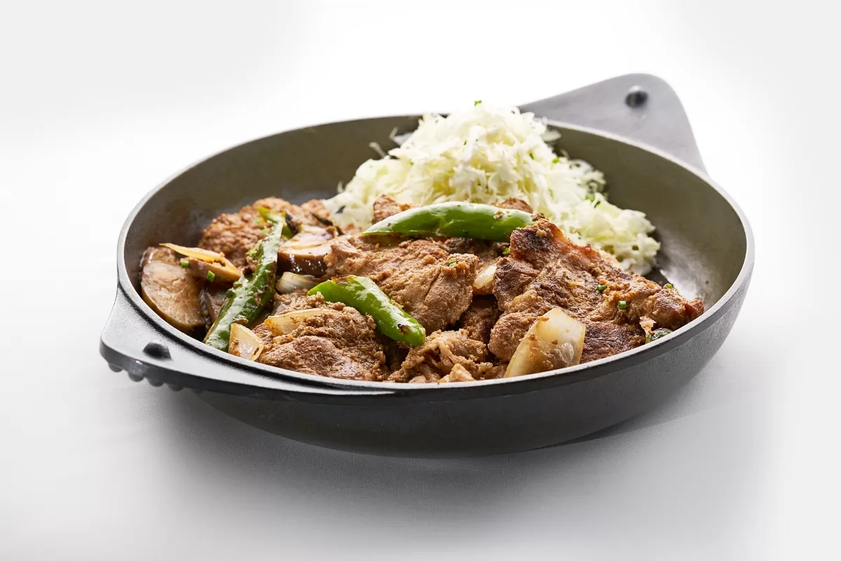 Buta shogayaki with tender pork slices cooked in ginger sauce and mushrooms served with shredded cabbage.