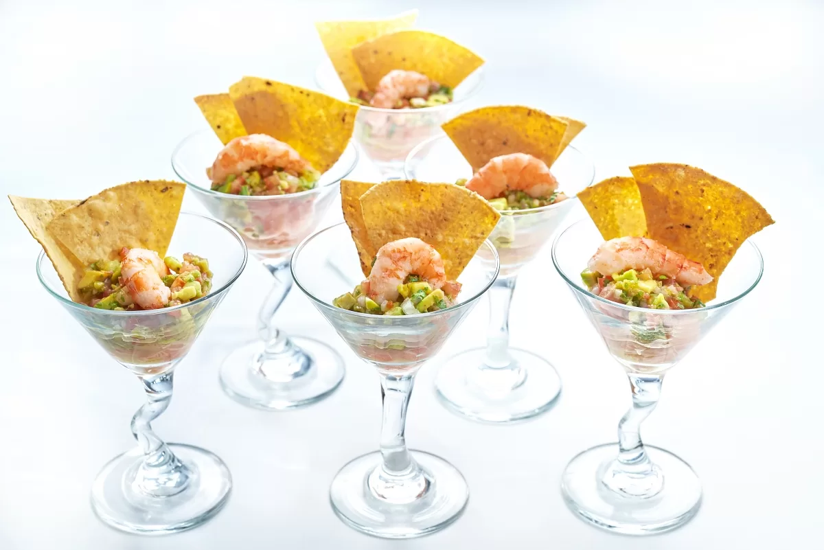 Ceviche with shrimp and diced vegetables, served in glasses with crispy chips.