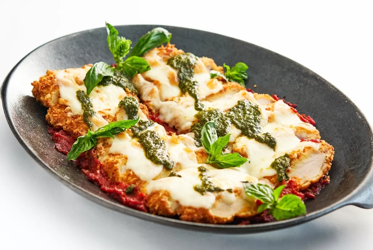 Chicken parmesan with breaded chicken topped with tomato sauce, melted cheese, and basil.