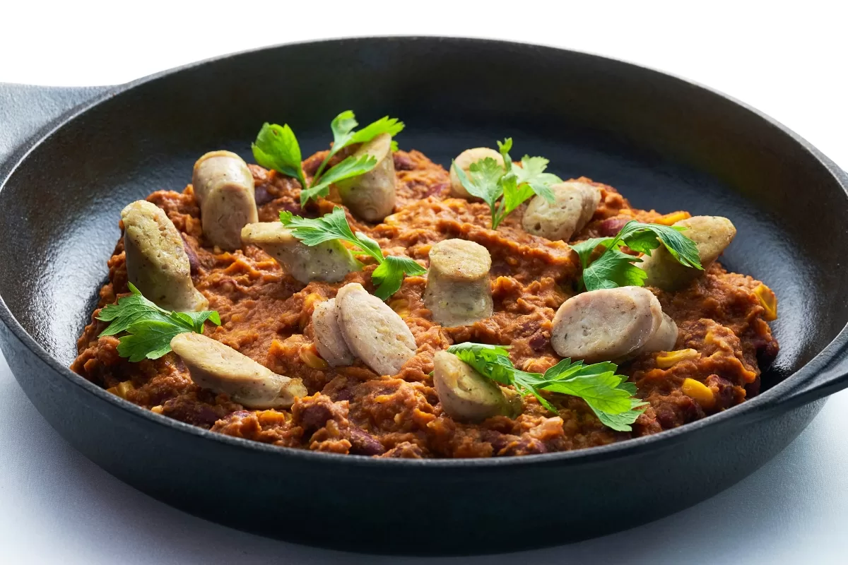 Chilli con carne with minced beef, spiced beans, and sausage slices, topped with cilantro.