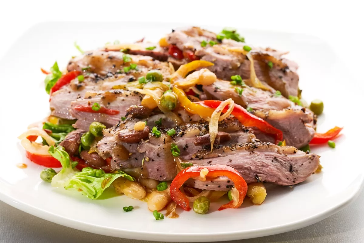 Duck breast salad with sliced duck, red paprika, mixed vegetables, and peanuts.