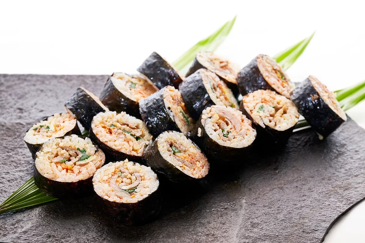 Korean rolled sushi with bulgogi beef, kimchi, and vegetables wrapped in seaweed and rice.