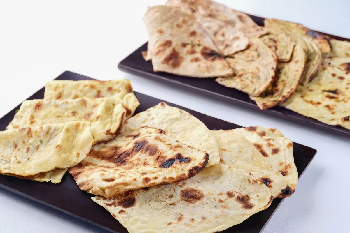 Naan bread on a black plate, served in the soup and salad station at Tirtha Buffet.