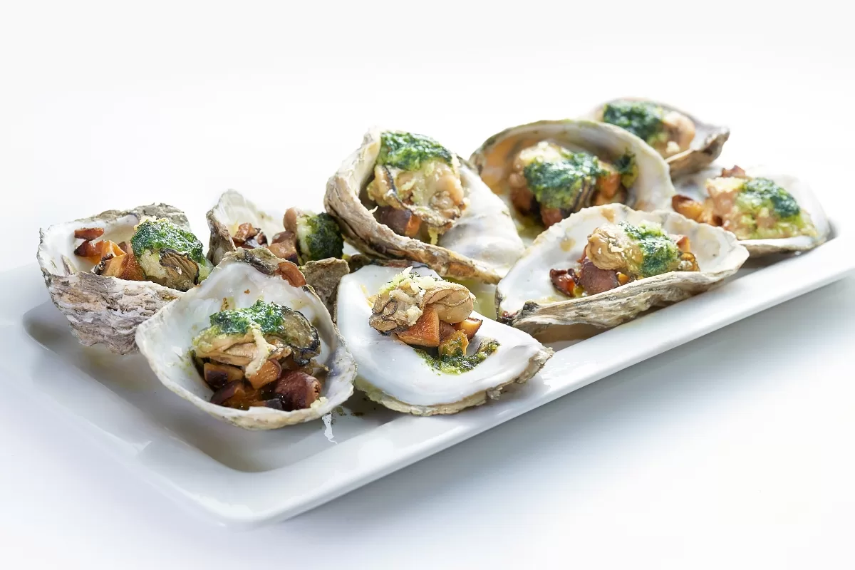 Oyster with escargot butter, featuring baked oysters drizzled with herb garlic butter sauce.