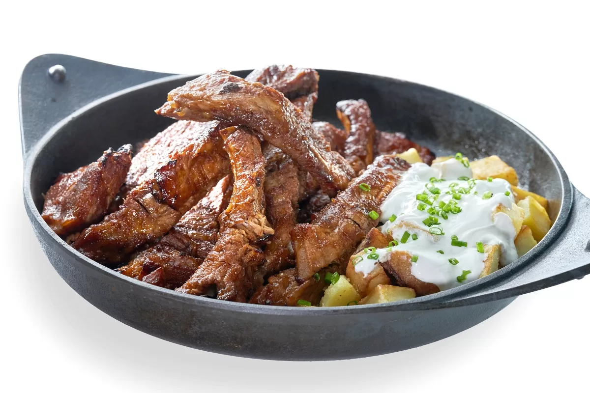 Roasted pork spareribs glazed with BBQ sauce, paired with potato wedges and sour cream.
