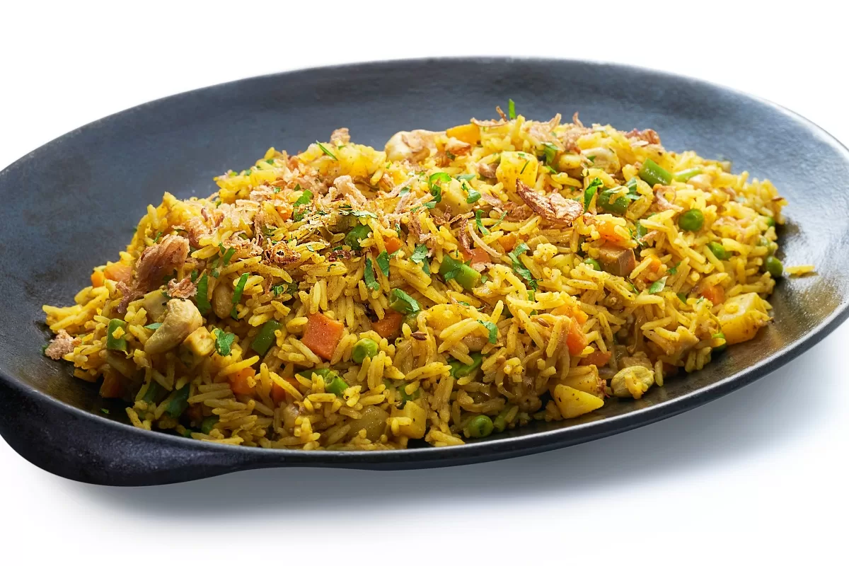 Royal biryani with spiced rice, meat, and mixed vegetables garnished with herbs.