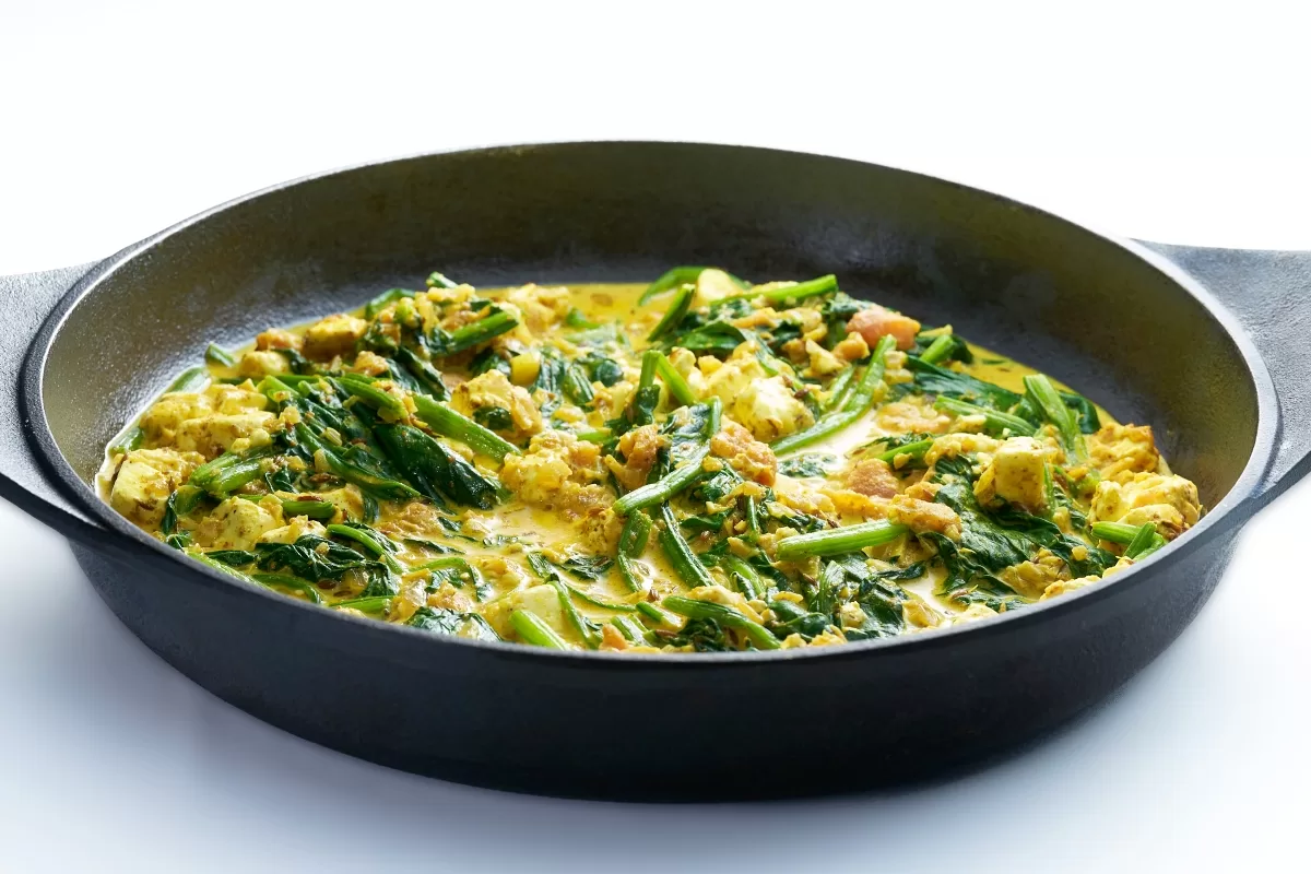 Saag paneer, a creamy spinach curry paired with soft paneer cheese, served in a pan.