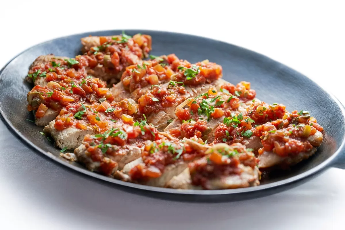 Stewed snapper topped with spicy tomato sauce.