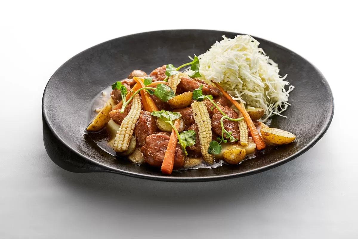 Teriyaki chicken with glazed chicken, baby corn, carrots, and potatoes served with shredded cabbage.